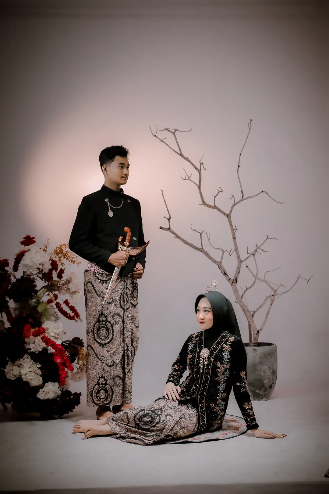 Adit berdiri memegang keris, Nadea bersimpuh menatap ke atas